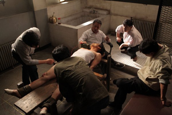 Jong-tae is tortured with electricity by Lee Doo-han, known as 'The Undertaker'